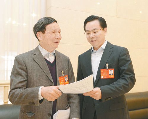 黄伯云代表（左）与刘国忠代表商讨完善《关于建立战略性新兴产业国家创新平台》的建议。 本报记者 张目 摄
